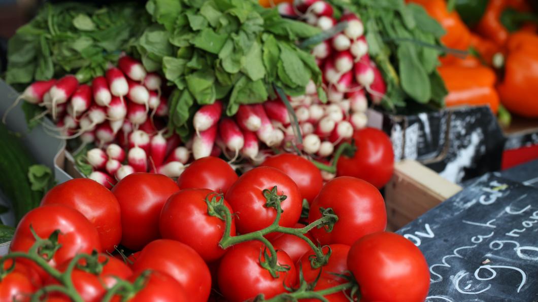 Tomaten en radijsjes uitgestald op een marktkraam.