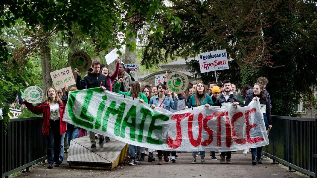 Een groep jongeren met een klimaatprotest vlag